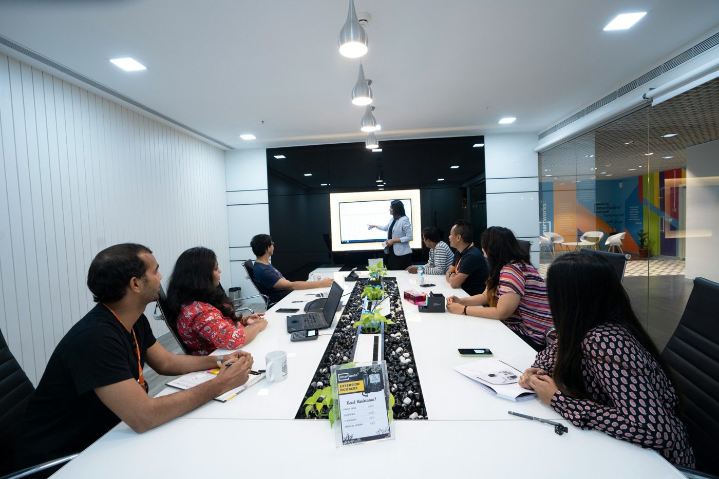 Une formatrice anime une session devant un groupe de managers réunis autour d'une table